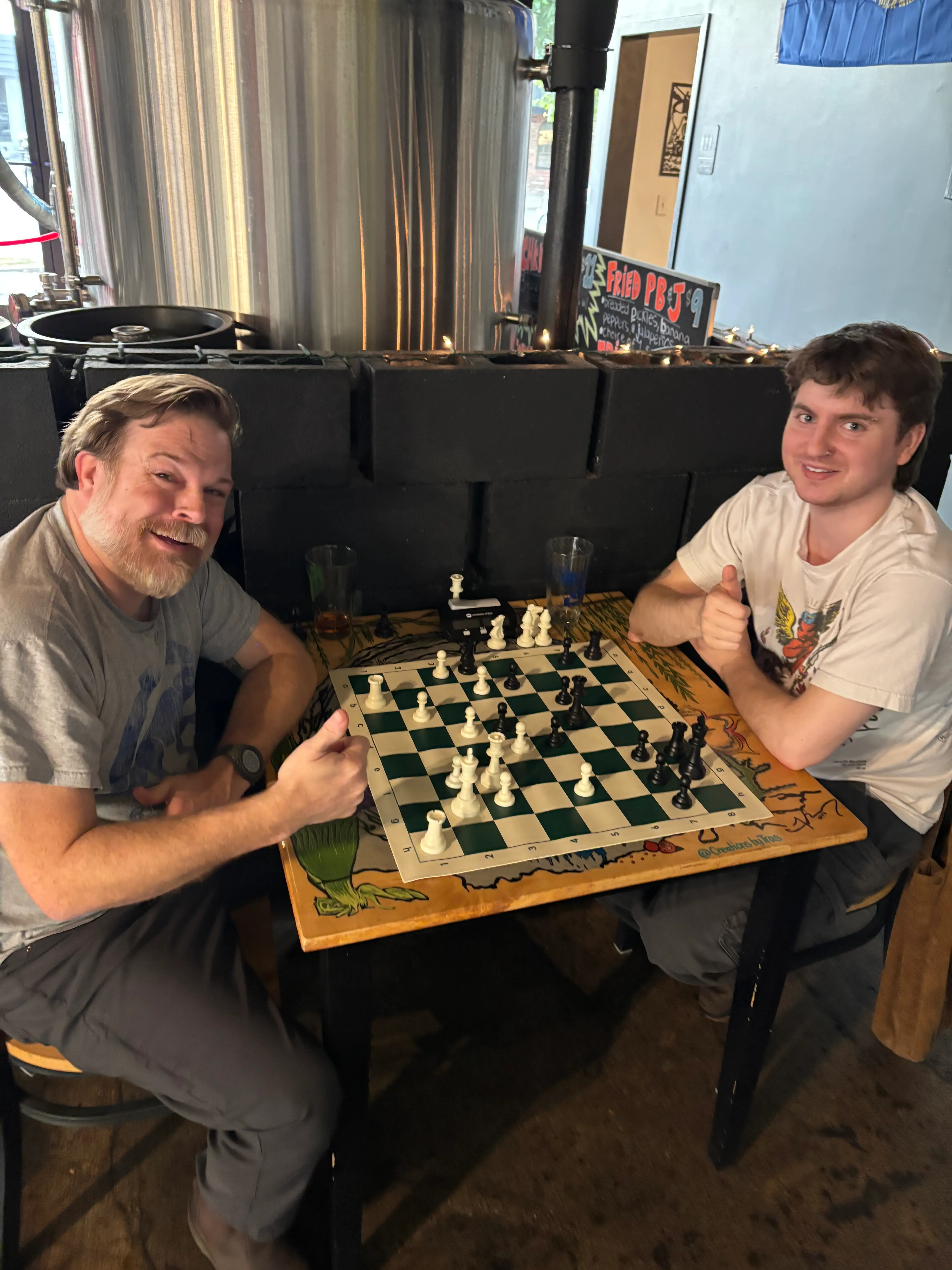 Two smiling men playing chess.
